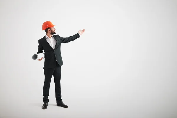 Homem em desgaste formal e um capacete de construção apontam sua mão towa — Fotografia de Stock