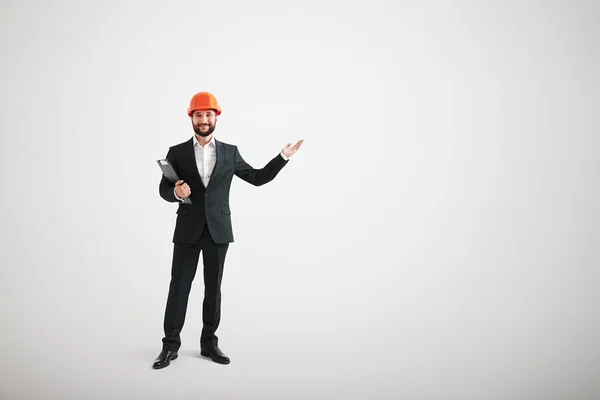 Man in formele slijtage en een helm van de bouw te wijzen in de dir — Stockfoto