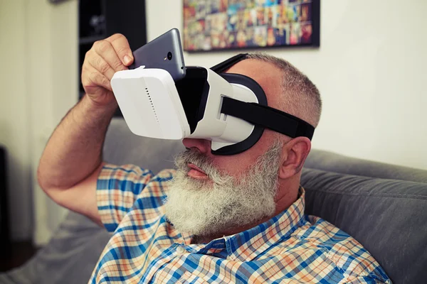 Man putting his phone inside virtual reality headset — Stock Photo, Image