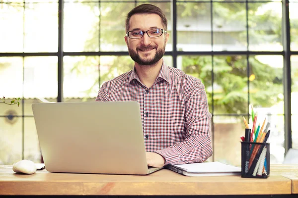 Portret van succesvolle lachende zakenman met zijn laptop — Stockfoto