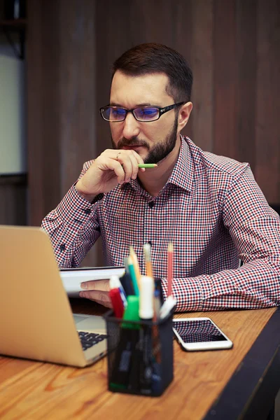 Серьезный бизнесмен смотрит на свой ноутбук — стоковое фото