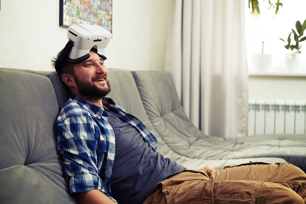 Joven descansando después de jugar juegos de ordenador de realidad virtual — Foto de Stock