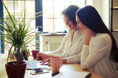 Bir defter ile bir masada oturan iki kadın