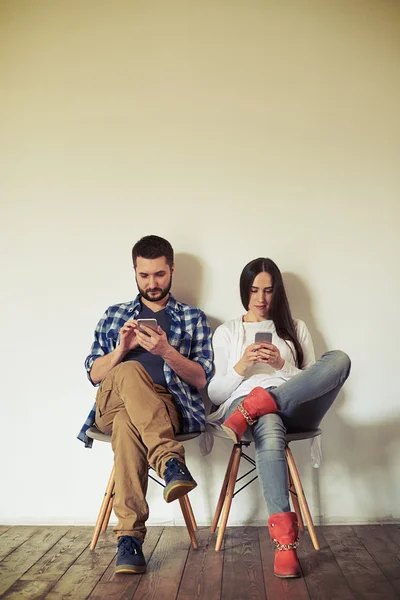 Άνδρας και γυναίκα εργάζονται σε smartphones τους — Φωτογραφία Αρχείου