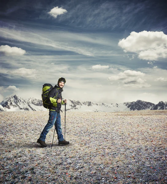 Člověk nosit zimní oblečení s trekingových holí v horách — Stock fotografie