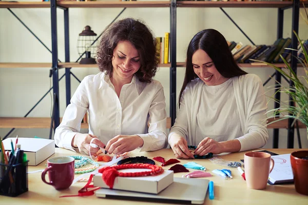 Zwei Frauen machen handgemachte rote Perlen — Stockfoto