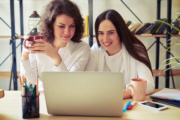 Две молодые женщины смотрят на ноутбук вместе — стоковое фото