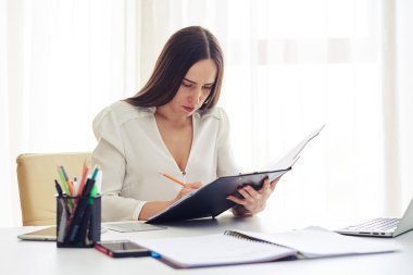 Woman correcting data in pad in the office