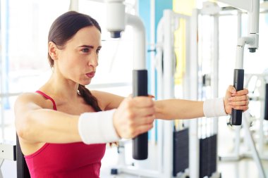 Beyaz kız spor salonunda kelebek makinesi üzerinde çalışıyor