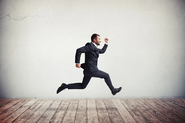 Hombre en ropa formal corriendo y saltando con sonrisa feliz —  Fotos de Stock