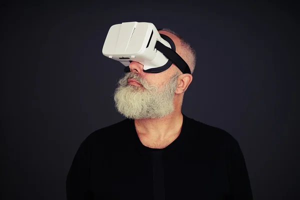 Senior man ser runt med hjälp av Virtual Reality glasögon — Stockfoto