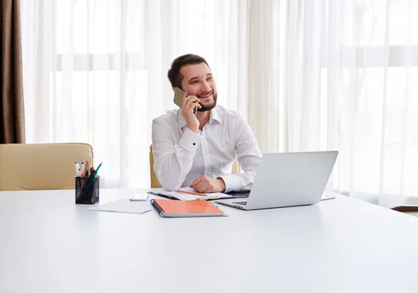 Χαμογελαστός άνθρωπος μιλάει στο τηλέφωνο στο σύγχρονο γραφείο — Φωτογραφία Αρχείου