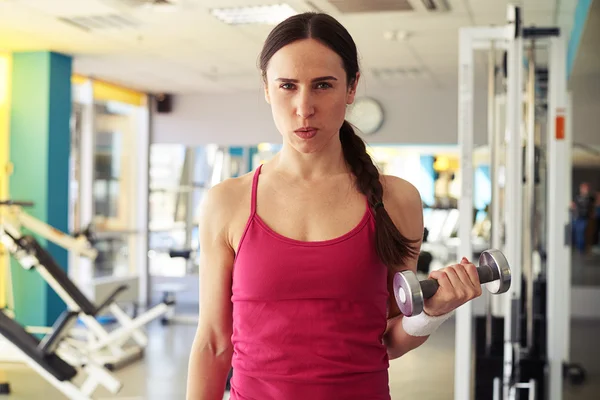 Brunette is working out with dumbbells in gym — Stock Photo, Image
