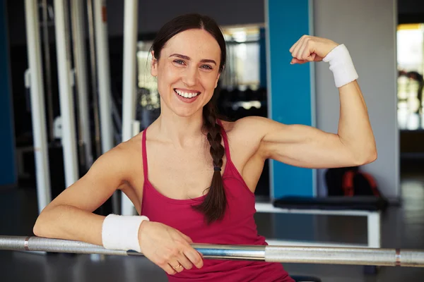 Frau zeigt im Sportverein ihren Bizeps — Stockfoto