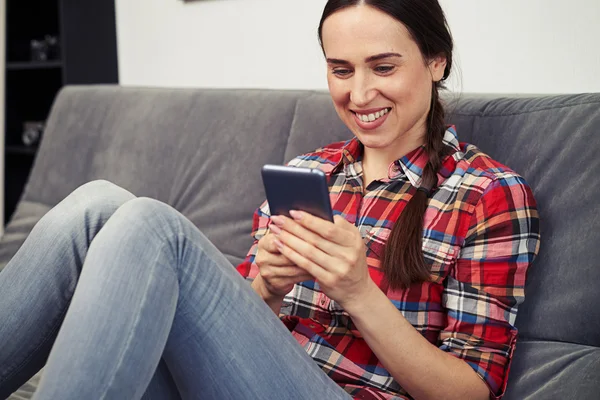 Mulher está fazendo algo no smartphone — Fotografia de Stock