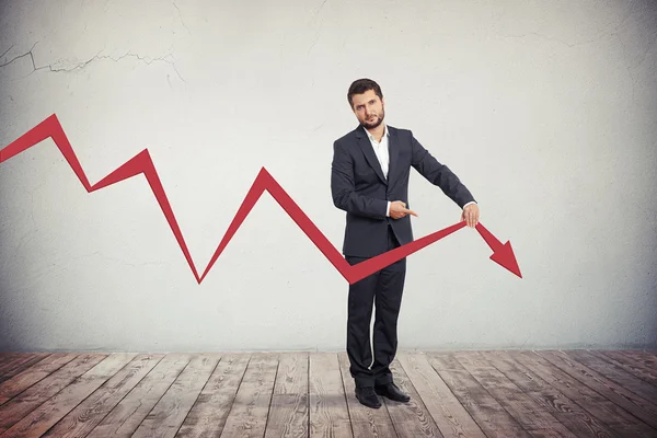 Businessman pointing to red graph arrow down. — Stock Photo, Image