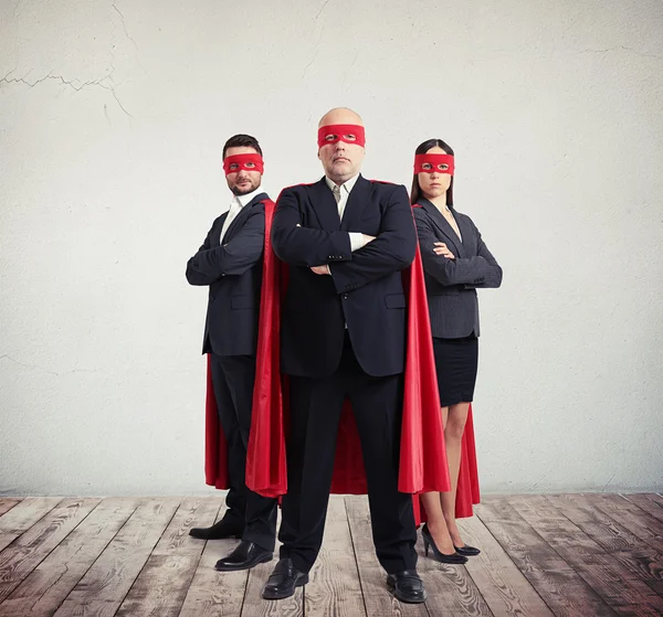 Twee zakenmannen en zakenvrouw in superheld kostuum — Stockfoto