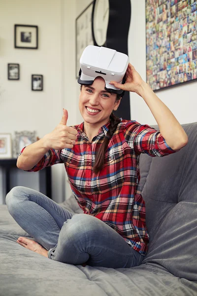 Woman sitting with virtual reality glasses and holding thumb up — Stock Photo, Image