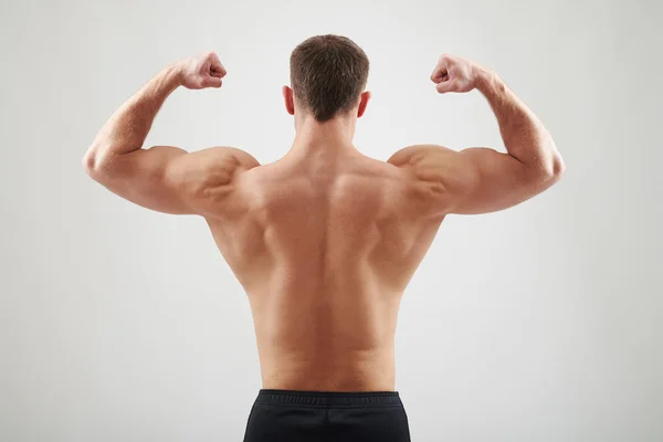 Espalda del hombre atlético mostrando músculos —  Fotos de Stock