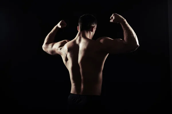 Visão traseira do cara sem camisa mostrando músculos — Fotografia de Stock