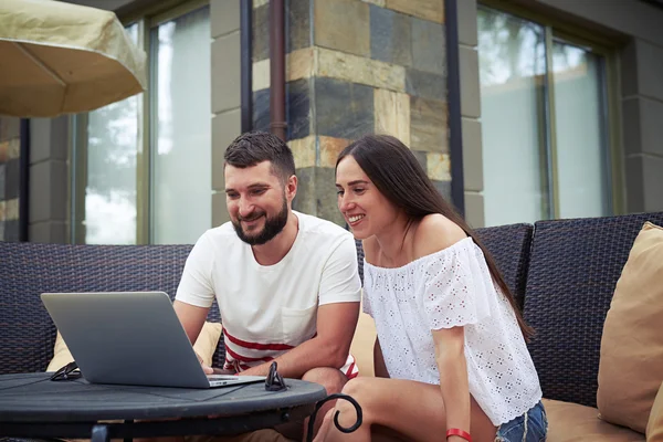 Lächelnder Mann und Frau mit Laptop auf der Terrasse — Stockfoto
