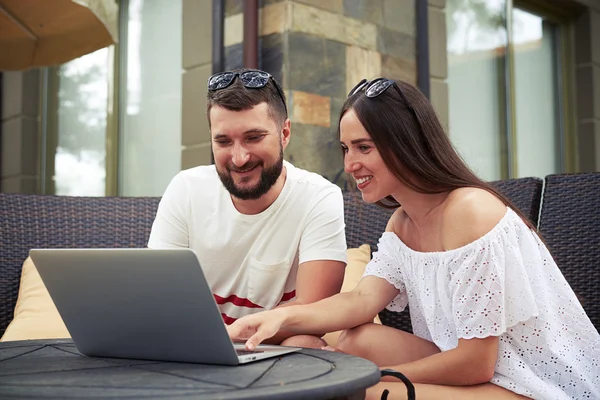 Lächelnde Frau und Mann mit Laptop im Hof — Stockfoto