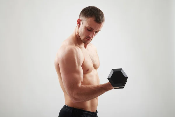 Muž s činka je prohýbání biceps — Stock fotografie