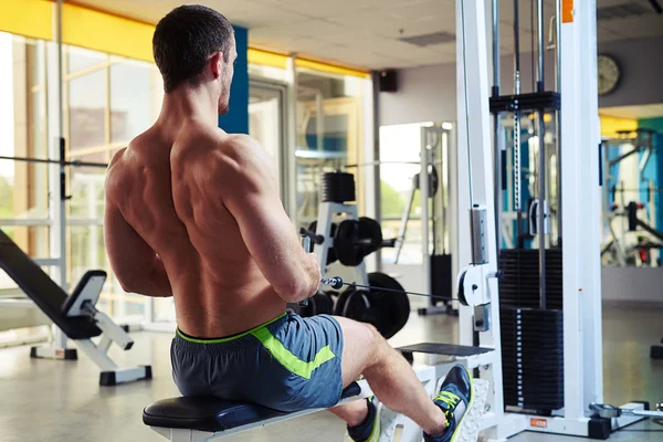 Giovane uomo che fa esercizio per la schiena in palestra — Foto Stock