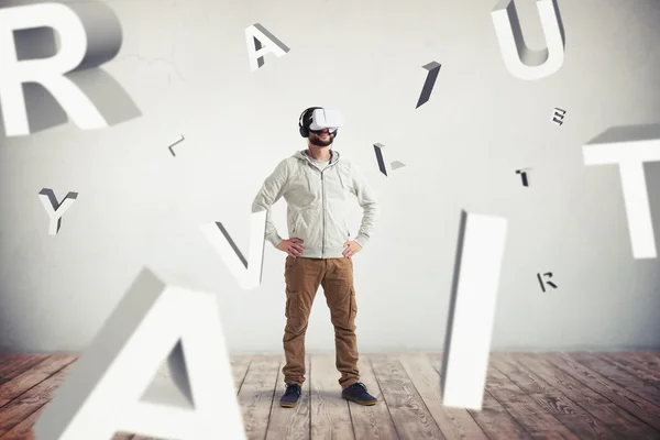 Hombre en gafas de realidad virtual y letras voladoras en floo de madera — Foto de Stock