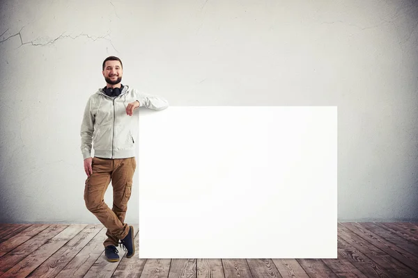 Pria di dekat poster besar di ruang putih — Stok Foto
