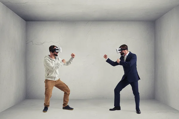 Two men in virtual reality glasses in grey empty room — Stock Photo, Image