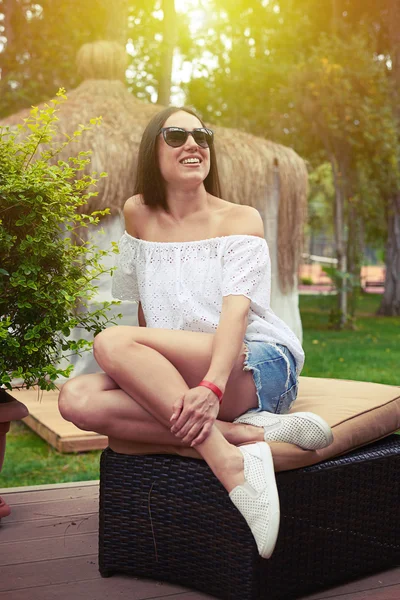 Ελκυστική νεαρή γυναίκα με γυαλιά ηλίου στον κήπο την ηλιόλουστη μέρα — Φωτογραφία Αρχείου
