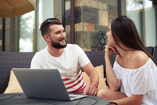 Lächelndes Paar plaudert auf der Couch auf der Terrasse im Hof — Stockfoto