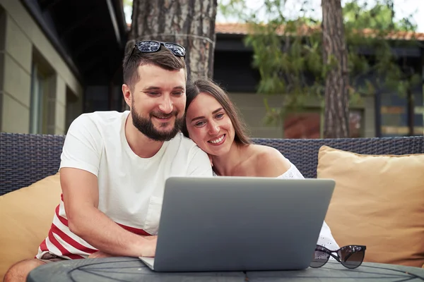 Casal sorridente relaxado no terraço está assistindo algo no lapto — Fotografia de Stock