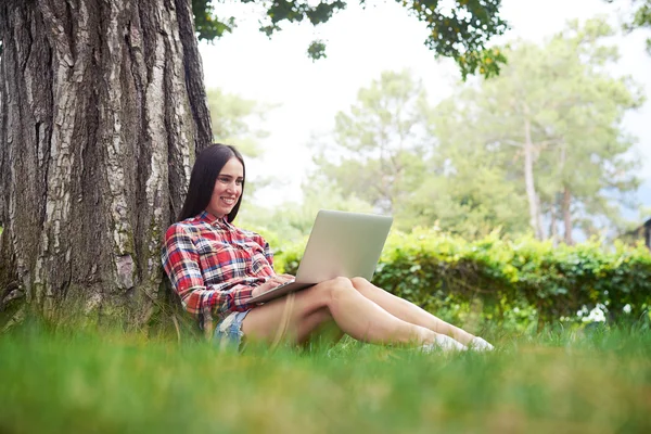 Giovane bella donna con computer portatile in giardino il giorno d'estate — Foto Stock