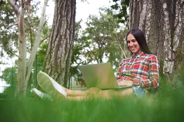 Jovem mulher de cabelos escuros gosta da natureza enquanto trabalha com laptop — Fotografia de Stock