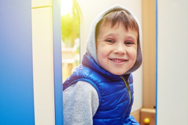  Küçük çocuk bir oyun alanında oturan ve gülümseyen