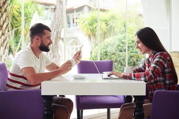 Uomo e donna insieme sulla terrazza utilizzando i loro gadget intelligenti — Foto Stock