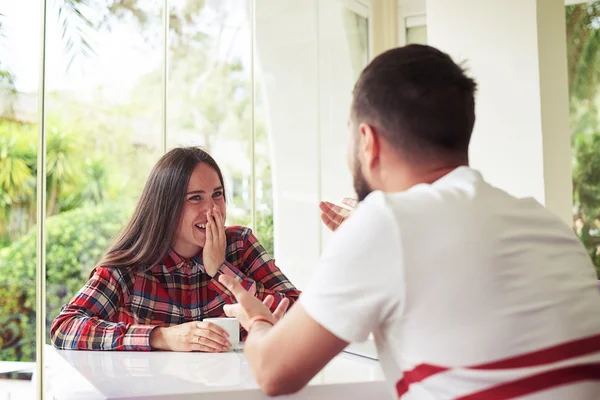 Jonge lachende paar is chatten in gezellige zonovergoten kamer — Stockfoto