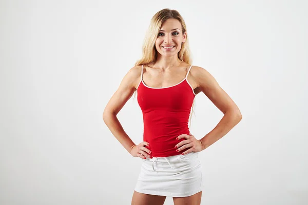 Bionda con corpo perfettamente allenato in top rosso su dorso bianco — Foto Stock