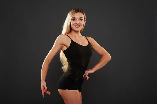 Красива атлетична жінка позує ізольовано на чорному тлі — стокове фото