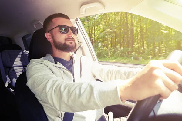 Beau mec confiant au volant de sa voiture par une journée ensoleillée — Photo