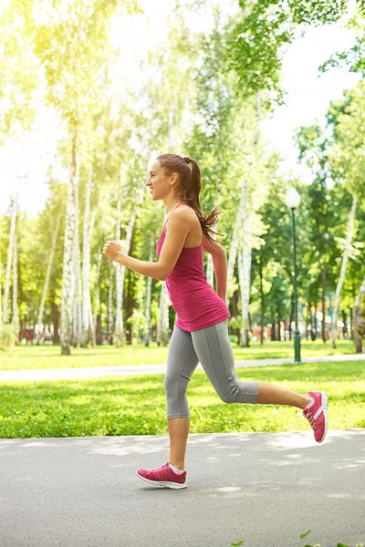 Sierlijke fit vrouw in huid-strakke sportkleding op een ochtend run in — Stockfoto