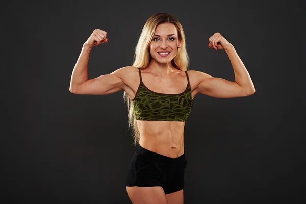 Σέξι γυναίκα σε χακί αθλητική κορυφή δείχνει μύες και κοιλιακούς — Φωτογραφία Αρχείου
