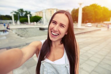  İçtenlikle selfie yaparken gülümseyen tulumiçinde çekici kadın 