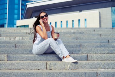  Genç gülümseyen kadın bir fincan kahve ile üzerinde konuşmaya başladın 