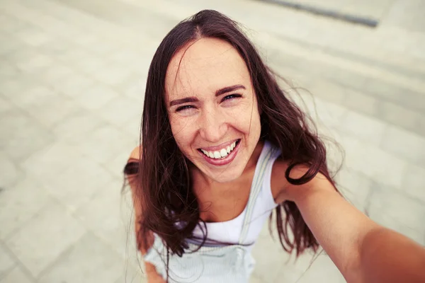 Mulher bonita com sorriso ingênuo fazendo uma selfie — Fotografia de Stock