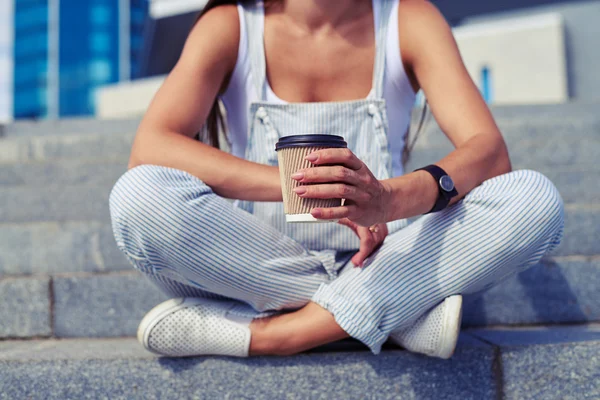 Primo piano di elegante seduta femminile con le gambe incrociate e una tazza — Foto Stock