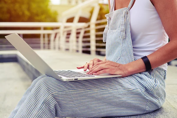 Primer plano de la mujer joven en ropa casual con ordenador portátil al aire libre —  Fotos de Stock