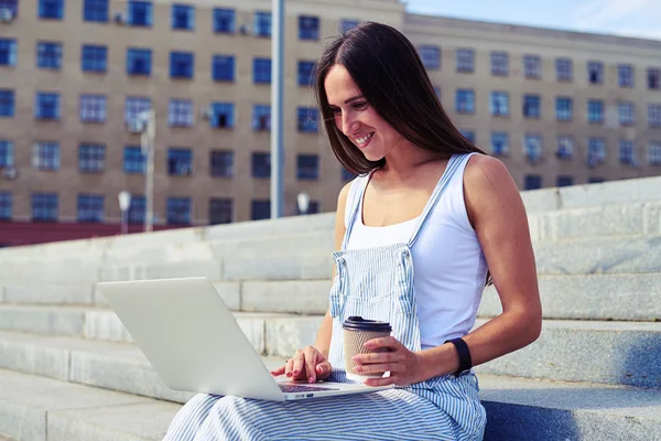 Portret van jonge vrouw met notebook computer zittend op trap — Stockfoto